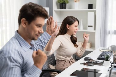 Gülümseyen mutlu iş arkadaşları beşlik çakıyor aynı zamanda yaratıcı proje planını yumrukluyor ve sabahları modern ofiste gündelik işlerde en yüksek kârı elde ediyorlar. Varsayım.