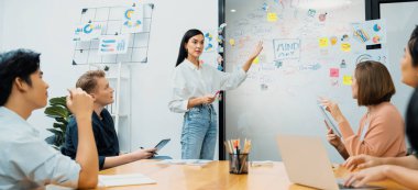 Genç ve güzel lider pazarlama stratejisini sunarken, uzman yatırımcı ve proje yöneticisi de yeni başlayan iş toplantısında iş performansını analiz etmeye çalışıyor. Çok ırklı bir grup. Tertemiz..