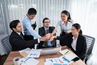 Kutlama jesti ve başarılı takım çalışması yapan bir grup mutlu iş adamı. Çeşitli yarış bürosu çalışanları şirket ofisinde pazarlama planlamasında ilerleme kaydettikten sonra kutlama yapıyorlar. Habiliment