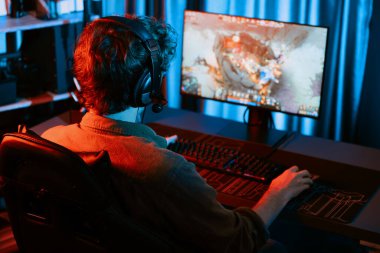 Savaş arenasında çoklu oyunlar takımıyla Moba 'da savaşan genç oyun flamasının sunucu kanalı, neon dijital ışık modern odasındaki arka görüntü ile bilgisayar monitöründe kulaklık takıyor. Toplayıcı.
