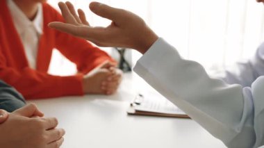 Çift, kısmen hamilelik planlaması için hastanede jinekologla doğum danışmanlığına gidiyor. Karı ve koca doktor randevusu boyunca dikkatle dinlerler. Ağır çekim. Katı.