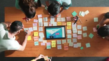 Tablet kablo prototipine bakarken, web tasarımı hakkında beyin fırtınası yapan ve planlayan programcıların tepeden tırnağa görüntüsü. Yetenekli müteahhit takımının dijital uygulamadan bahseden hava görüşü. Sempozyum.