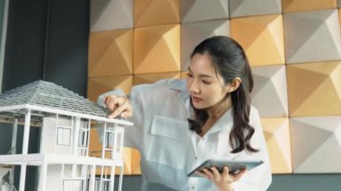 Tablet kontrol evi modelini kullanan güzel bir proje yöneticisi. Mimar mühendisinin portresi tabletteki veri analizini kullanarak bina inşaatını denetliyor. İş inşaat konsepti. Yönlendirici.