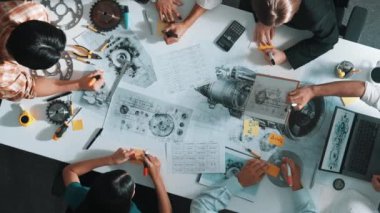 Üstten görünüşlü akıllı mühendis ekibi metal teçhizatlı, hesap makineli, yapışkan notlu türbin motor yapısı hakkında konuşuyor. Bir grup teknisyen toplantıda not alıyor. Hizalama.