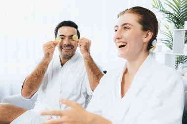 Bornozlu mutlu bir çift, salatalıkla oynuyor ve tatil boyunca gündüz ambians spa salonunun ya da otelin tadını çıkarıyor. Şımarık yüz spa 'sı ve cilt bakımı, esans rahatlığı. Sessiz.
