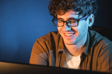 Neon Light Modern Ofis 'te yaratıcı bir başlangıç projesi için bilgisayara odaklanan gülümseyen genç iş adamı. Düşünüyorum da, pazarlama ağı yaratıcıdan pazar kanalı tasarım konseptine çevrimiçi planlama. Toplayıcı.