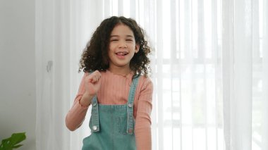 Mutlu Afro-Amerikan kızları oturma odasında dans ederken. Hip hop kızı egzersiz yapıyor ve çocukluk yaşam tarzında aerobik ya da serbest dans yapıyor. Sportif kız kafiyeli oldu. Pedagoji.