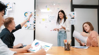 Genç ve yakışıklı beyaz adamın el kaldırması ve soru sorması. Bu arada genç ve güzel lider iş görüşmeleri arasında zihin haritası ve renkli grafikler kullanarak iş planı sunuyor. Tertemiz..