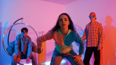 Çekici mutlu dansçı kameraya bakarken zeki kadın neon ışıkla kafiyeli hareket ediyor. Profesyonel İspanyol şarkıcı çeşitli arkadaşlarıyla renkli kıyafetler giyerken break dans yapıyor. Mutluluk.