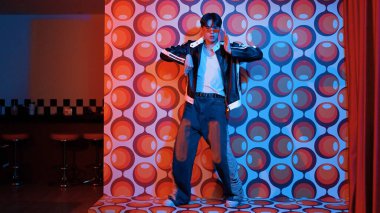 Asyalı break dansçı serbest stile geçiyor ve balon arka planlı kameraya bakıyor. Profesyonel hippi gündelik kıyafet giyer ve gözlük takar. Mutluluk.