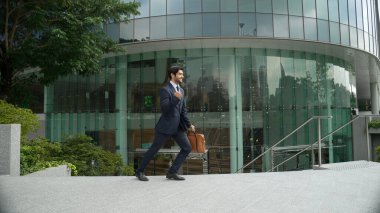 Şehir merkezinde dikilirken resmi takım elbise giyen yetenekli bir iş adamı. Proje yöneticisi resmi takım elbise giyerken binanın önünde duruyor. Ofisteki adam yeni bir iş arıyor. Sevinçli..