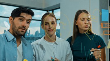 Profesyonel iş adamları beyin fırtınası yapıyor, fikir paylaşıyor, düşünüyor yetenekli erkek liderler cam duvarda yapışkan notlar yazarken. Yetenekli yönetici ofisteki cam duvara iş planı koymuş. İzleme