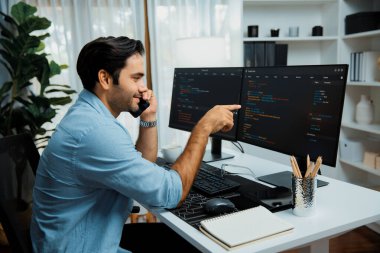 Akıllı IT geliştirici yöneticisi, bilgisayar ekranındaki yazılım kodlama sistemindeki sorunu çözen iş arkadaşına seslenerek modern ofiste uygulama programı güncellemesi yapıyor. Tahmin et..