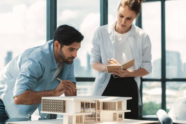 Akıllı beyaz mimar mühendis takımı ev modelini ölçmek için birlikte çalışıyor. Bir grup profesyonel iç mimar tasarım inşaatı hakkında fikir paylaşımı ve beyin fırtınası yapıyor. İzleme.