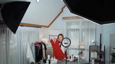 Kadın nüfuzlu kişi video görüntülerini canlı yayınlıyor. Kıyafetler sosyal medyada ya da blogda yer alıyor. Stüdyo ışıklandırmalı mutlu genç kız çevrimiçi pazarlama oturumu yayını için..