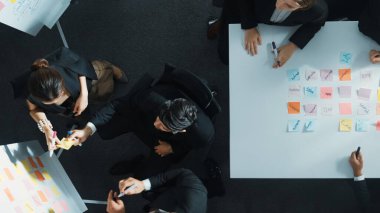 Toplantı odasında yapışkan notlar kullanarak iş grubunu paylaşma ve beyin fırtınası fikrine yukarıdan aşağı bakış. Yatırımcı, pazarlama stratejisini yazarken, aynı zamanda müdürden de not alıyor. Müdürlük.