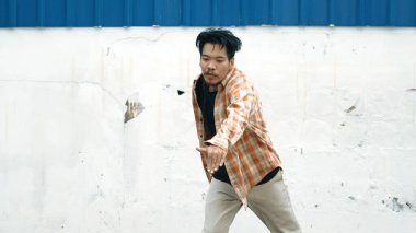İspanyol komedi koreografı hip hop tarzında dans ediyor. Genç mutlu break dansçı B-boy dansı yapıyor. Sokak dansı yapan komik adamın hareket çekimi. Açık hava sporu 2024. Modern dans. hiphop.