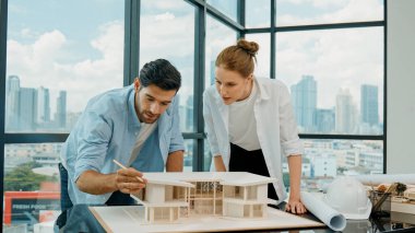 Kooperatif mimar mühendis ekibi kalem kullanarak ev modelini ölçmek için birlikte çalışıyor. Başarılı bir Kafkas iç mimari tasarım ekibi mimari model yapısını inceliyor. Tasarım. İzleme
