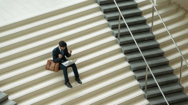 Üst düzey bir iş adamı merdivenlerde otururken başarılı bir projeyi kutluyor. Akıllı proje yöneticisinin yeni bir iş bulması, terfi alması, bilgisayar kullanarak arkadaşlarını arayarak satışları artırması. Sevinçli..