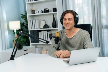 Sunucu kanalı, gülümseyen akıllı yayıncı kaydı, senaryosu ve akıllı telefonuyla sosyal medyada sohbet programı, kulaklık takarak modern ev stüdyosundaki video flamalarını kaydediyor. Bireysel.