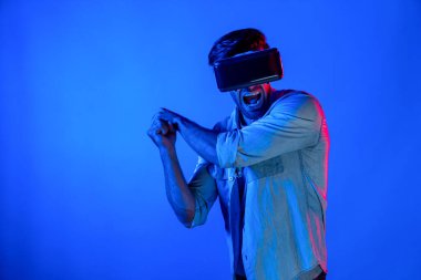 Kafkasyalı bir adam VR cam takıyor ve hareket eden el kol kılıcını tutuyor. Oyuncu, gelecekteki sanal gerçeklik kulaklığını ya da gelecekteki yenilikleri kullanarak meta dünyaya giriyor ya da aksiyon oyunu oynuyor. Sapma.