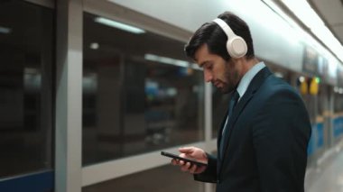 Proje yöneticisi tren istasyonunda şarkı seçmek için cep telefonu tutarken kulaklık takıyor. Zeki iş adamı bulanık geçmişi olan treni beklerken saati kontrol ediyor. Sevinçli..