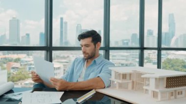 Ev tasarımını düşünürken yetenekli bir mühendisin portresi tasarımı kontrol ediyor. Profesyonel iş adamı projeyi seçerken mimar modeline, yazısına, çizimine, taslağına bakıyor. Tartışma