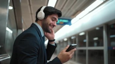 Tren istasyonunda geçmişi bulanık bir şekilde beklerken kulaklıkla müzik dinleyen zeki bir iş adamı. Yetenekli proje yöneticisi cep telefonu tutarken dinlenme sesi dinlemeyi sever. Sevinçli..