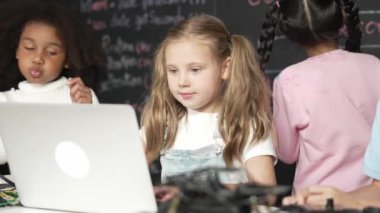 Akıllı beyaz kız, BTMM teknoloji sınıfındaki çok kültürlü arkadaşlar tarafından çevrelenmiş dizüstü bilgisayar programlama kodları ve yazma programı kullanıyor. Etkinlik.