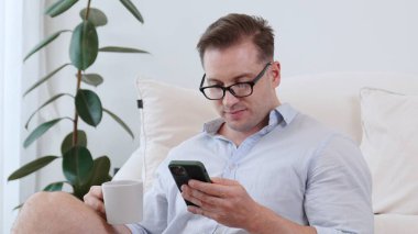 Orta yaşlı bir adam, iş için telefon arama verilerini kullanarak, çocukları iyi bir yetişkin ya da eğlence olsun diye odada kahve fincanıyla koltukta oturur. İşadamı teknolojiyi kolaylık için kullanır. Uyumsuzluk.