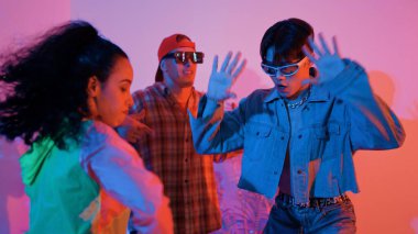 İspanyol hipster renkli kıyafetler giyer ve serbest stil müziğe el sallar. Profesyonel break dansçı neon ışıklarıyla ve modern stüdyo arkadaşlarıyla coşkuyla dans ediyor. Mutluluk.