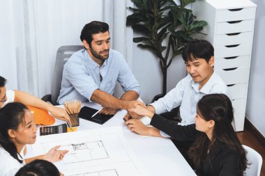 Çeşitli inşaat mühendisi ve müvekkil grupları mimari proje üzerinde başarılı bir anlaşma yaptıktan sonra el sıkışıyor, inşaat planını gözden geçiriyor ve toplantı masasında plan oluşturuyor. Tedbirli