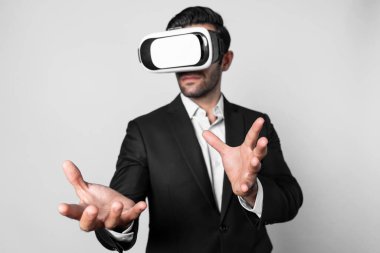 Uzman iş adamı metaevrene girmek için sanal gerçeklik gözlüğü kullanırken elinde bir şey tutuyor. Proje yöneticisi giysi ve sanal gerçeklik gözlüğü takarken veri analizine bakıyor. Yenilik. Sapma.