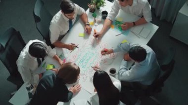 Profesyonel iş adamlarının zihin haritasını kullanarak beyin fırtınası yapmak için birlikte çalıştıklarına dair üst düzey bir görüş. Akıllı yöneticilerin sürdürülebilir enerji hakkında konuştuğu ve tartıştığı hava görüntüsü. Hizalama.