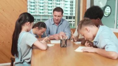 Sıradan tişörtlü zeki liseli çocuk, karışık ırkları olan öğrenciler kitap yazarken profesyonel öğretmene soruyor. Yaratıcı çocuk notayı işaret ederken Kafkas eğitmeni yorum yapıyor. Öğretim