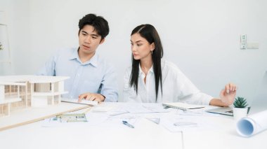 Profesyonel erkek mühendis ev modelini cetvel kullanarak ölçerken güzel bir kooperatif iş arkadaşı verileri analiz etmek için dizüstü bilgisayar kullanarak birlikte çalışıyor. Yaratıcı tasarım ve takım çalışması. - Yakın çekim. Tertemiz..