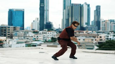 Profesyonel Asyalı break dansçı B çocuk dansı yaparken çatıda çok kültürlü arkadaşlar var. Genç modern dans grubu hip hop hareketi yapıyor. Tarz, moda, aksiyon. Açık hava sporu 2024. Hiphop.