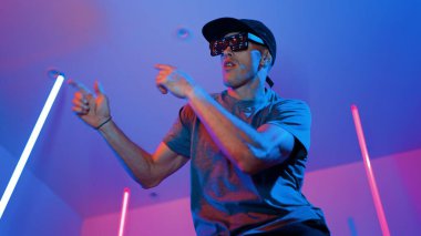 Beyaz dansçının gösterişli gözlükler taktığı ve break dans yaptığı alçak açılı kamera. Çekici adam kendinden emin bir şekilde kameraya bakarken enerjik bir performans ve hareket gösterdi. Mutluluk.