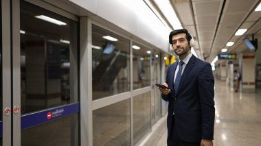 Proje yöneticisi tren istasyonunda şarkı seçmek için cep telefonu tutarken kulaklık takıyor. Zeki iş adamı bulanık bir geçmişi olan treni beklerken rahatlatıcı müzik dinliyor. Sevinçli..