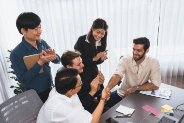 Çeşitli ofis çalışanları stratejik iş pazarlama toplantısı üzerine anlaşma yaptıktan sonra el sıkışıyor. Takım çalışması ve olumlu tutum verimli ve destekleyici bir iş yeri yaratır. Tedbirli