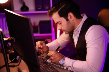 Akıllı işadamı, gece geç saatlerde mor neon ışıklı odadaki disiplin ürün hizmetlerinin online satış kanalını analiz etmek için kağıt işleri rapor klasörüne not pazarı verileri yazıyor. Tahmin et..