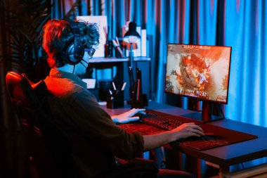 Savaş arenasında çoklu oyunlar takımıyla Moba 'da savaşan genç oyun flamasının sunucu kanalı, neon dijital ışık modern odasındaki arka görüntü ile bilgisayar monitöründe kulaklık takıyor. Toplayıcı.