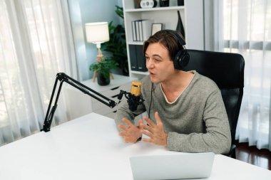 Sunucu kanalı, gülümseyen akıllı yayıncı kaydı, senaryosu ve akıllı telefonuyla sosyal medyada sohbet programı, kulaklık takarak modern ev stüdyosundaki video flamalarını kaydediyor. Bireysel.