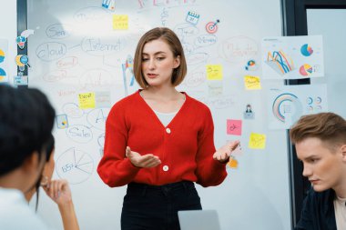 Profesyonel çekici kadın lider, modern iş toplantı odasında beyin fırtınası zihin haritalama istatistikleri ve renkli yapışkan notlar kullanarak yaratıcı pazarlama planını sunuyor. Tertemiz..