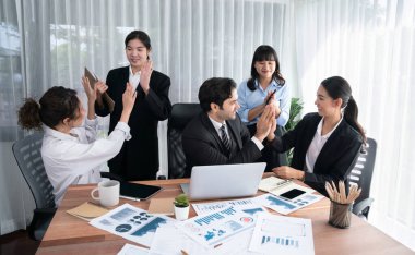 Bir grup mutlu iş adamı beşlik bir jest ve başarılı bir takım çalışması yapıyor. Çeşitli yarış bürosu çalışanları şirket ofisinde pazarlama planlamasında ilerleme kaydettikten sonra kutlama yapıyorlar. Habiliment