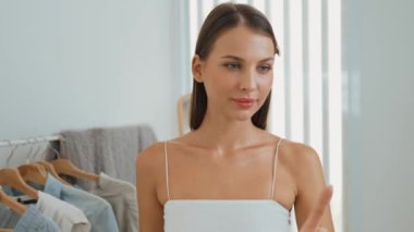 Genç sosyal medyum kadın moda videosu yapıyor. Blogcu kameraya selfie çubuğu ve ışık halkası kullanarak gülümserken, aynı zamanda ikna edici çevrimiçi kıyafetlerin izleyicilere veya takipçilere vlog satmasını sağlıyor. Düzenle