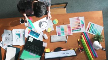 Kulaklıktan müzik dinlerken yetenekli iç dizayn grafiklerinin yukarıdan aşağı havadan görüntüsü. Proje yöneticisi kulaklıkla çalışırken ve rahat şarkılar dinlerken stüdyoda hareket ediyor. Sempozyum.