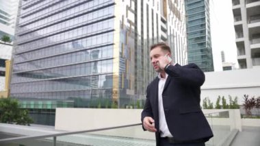 Zeki beyaz iş adamı, çatıda dururken iş arkadaşını mali strateji planlaması için arıyor. Proje yöneticisi pazarlama ekibiyle iletişim kurmak için cep telefonunu kullanıyor. Yaşam tarzı. Urbane.