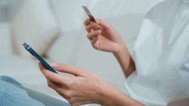 Kadın alışverişi ya da internet pazarında online ödeme modern yaşam tarzı için satılık eşyalar arıyor ve canlı siber güvenlik yazılımı tarafından korunan cüzdandan çevrimiçi ödeme için kredi kartı kullanıyor