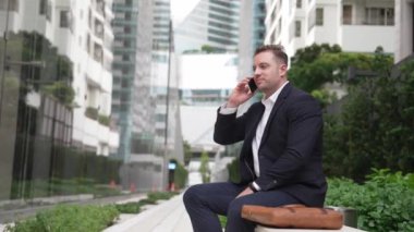 Kafkasyalı işadamı, müdürle telefonda plan stratejisi hakkında konuşurken bankta oturuyor. Profesyonel yönetici pazarlama ekibini arıyor ve şehirde yaratıcı fikirleri paylaşıyor. Urbane.